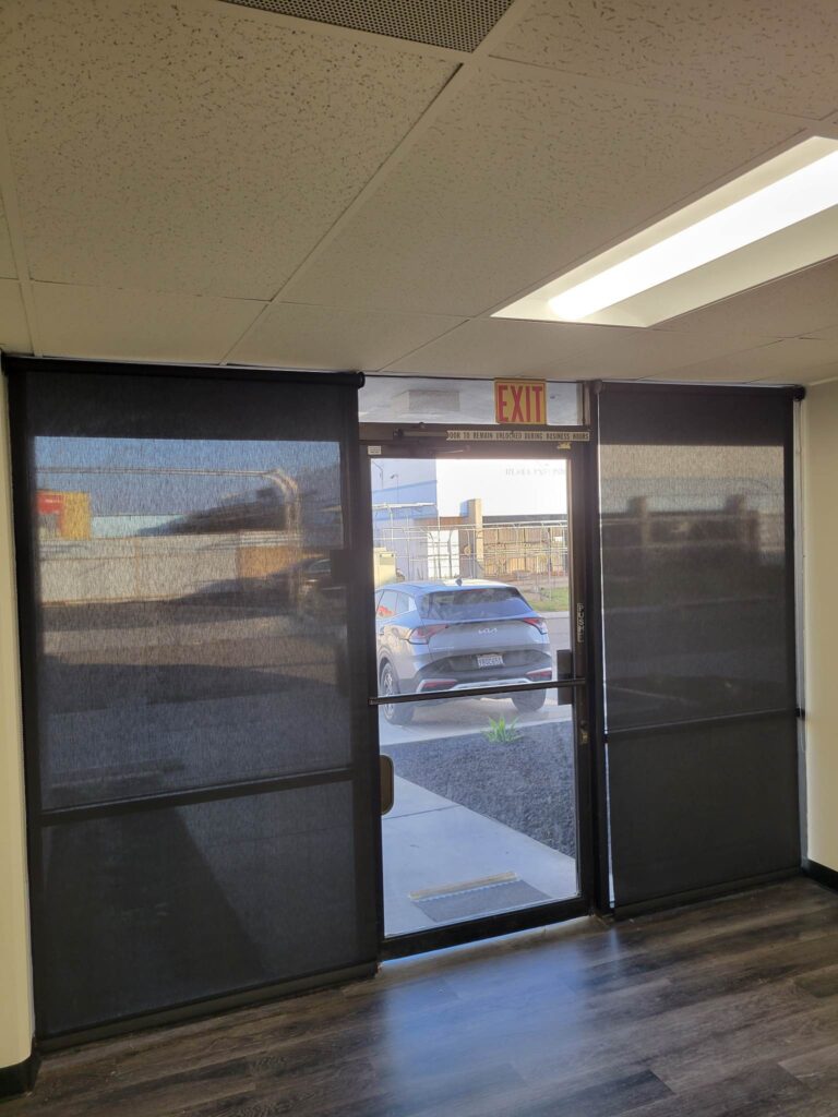 Black roller shades installed on a business entrance in Orange County