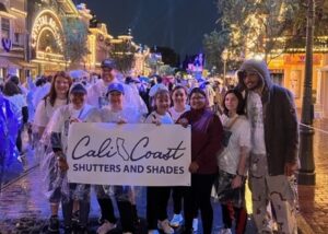 CHOC Walk 2023, the Cali Coast Shutters team poses on Main Street USA with the team banner in Disneyland