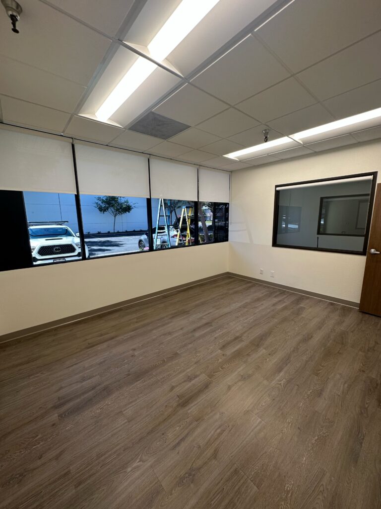 An office space showing new custom Roller Shades half open on windows, giving the space an upgraded look.